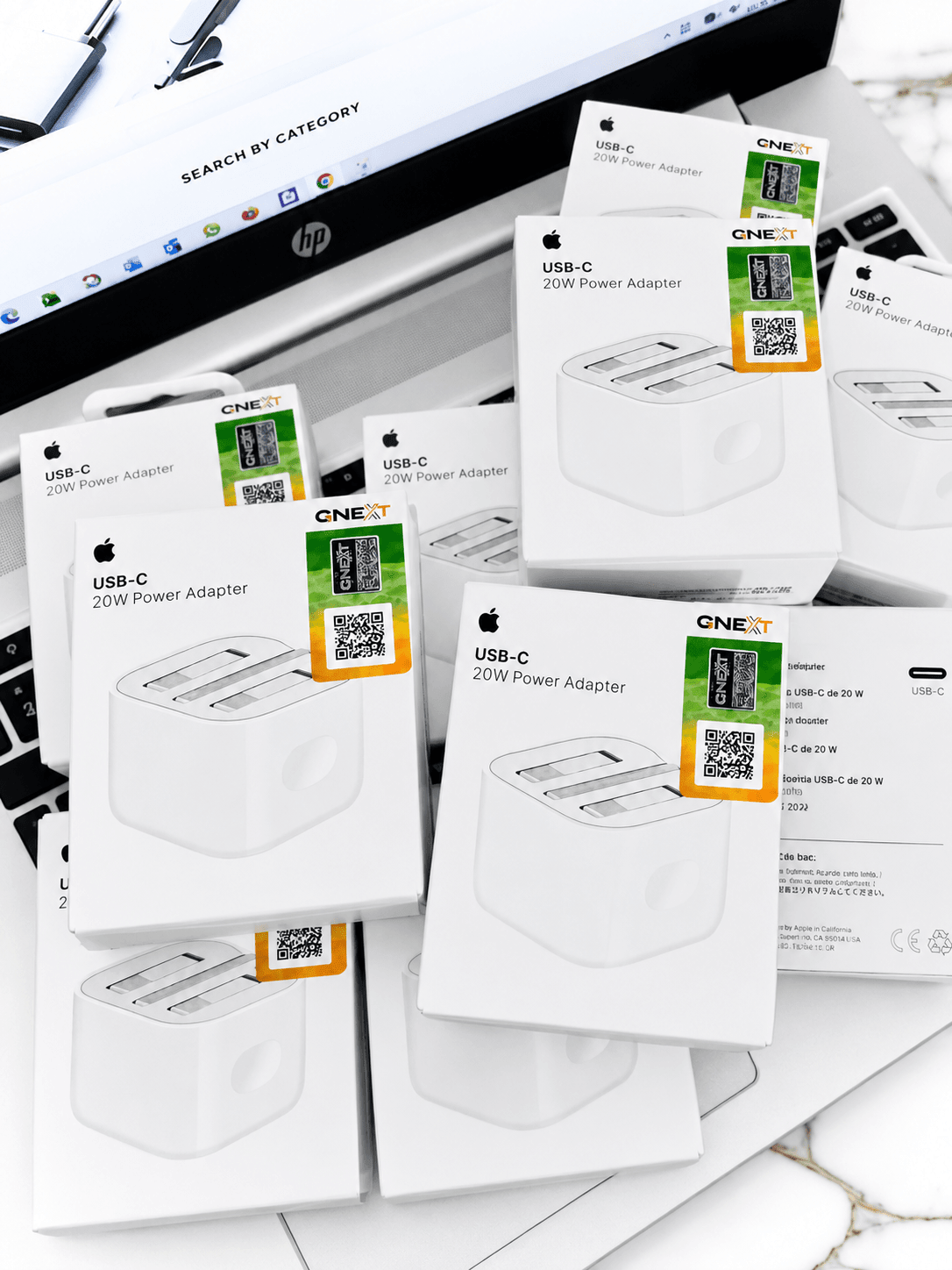 Multiple white boxes of USB-C 20W Power Adapters arranged on a white surface.