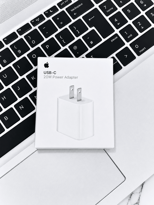 Apple USB-C 20W Power Adapter box resting on a laptop keyboard