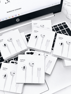 Multiple boxes of Apple EarPods USB-C headphones placed on a laptop keyboard.
