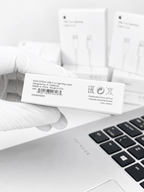 Close-up of an Apple USB-C to Lightning cable box label held by a gloved hand.