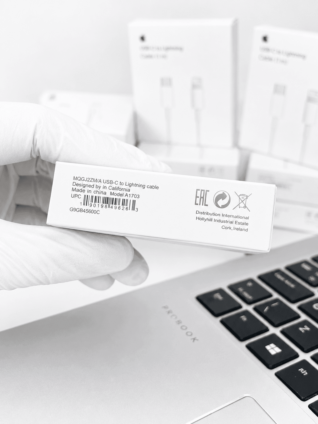 Close-up of an Apple USB-C to Lightning cable box label held by a gloved hand.