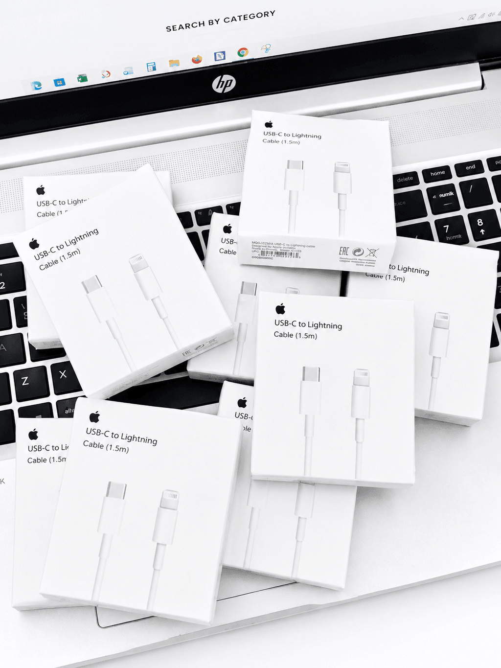 Multiple USB-C to Lightning cable boxes scattered on a laptop keyboard