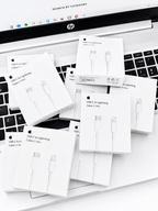 Multiple USB-C to Lightning cable boxes scattered on a laptop keyboard