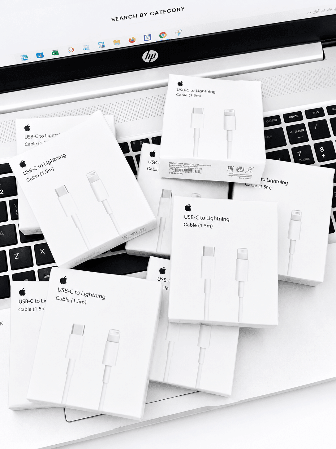 Multiple USB-C to Lightning cable boxes scattered on a laptop keyboard