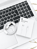 White USB-C to Lightning cable and packaging resting on a laptop keyboard