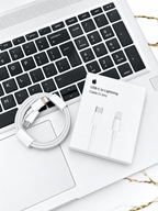 White USB-C to Lightning cable and packaging resting on a laptop keyboard
